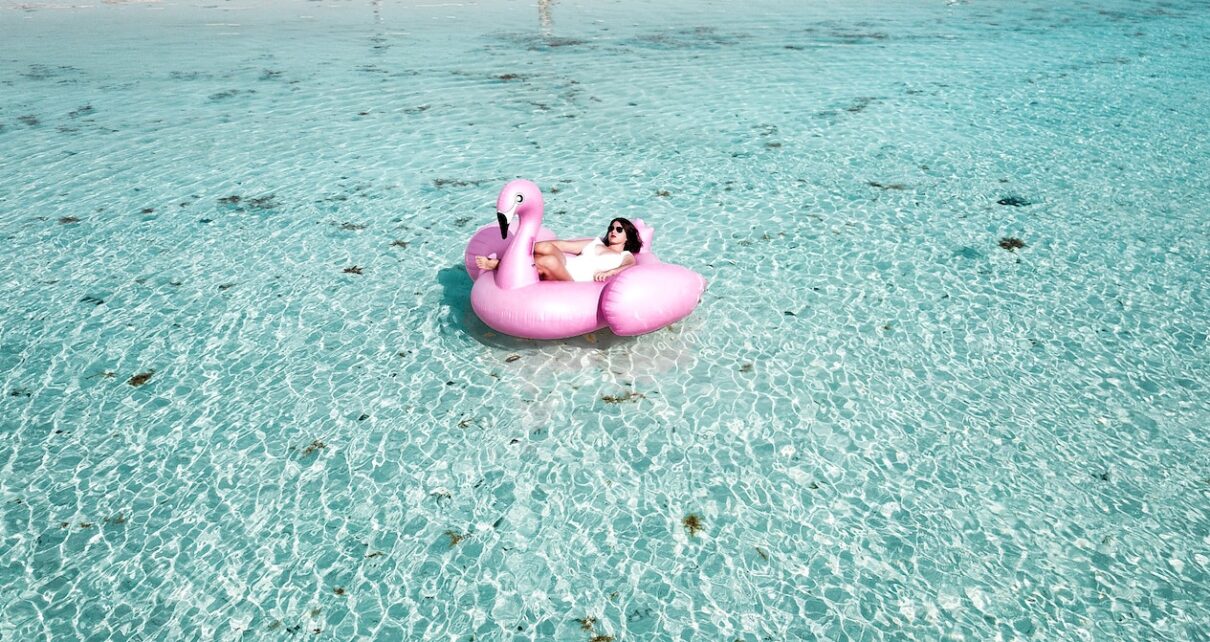 Woman Lying on Pink Flamingo Bouy